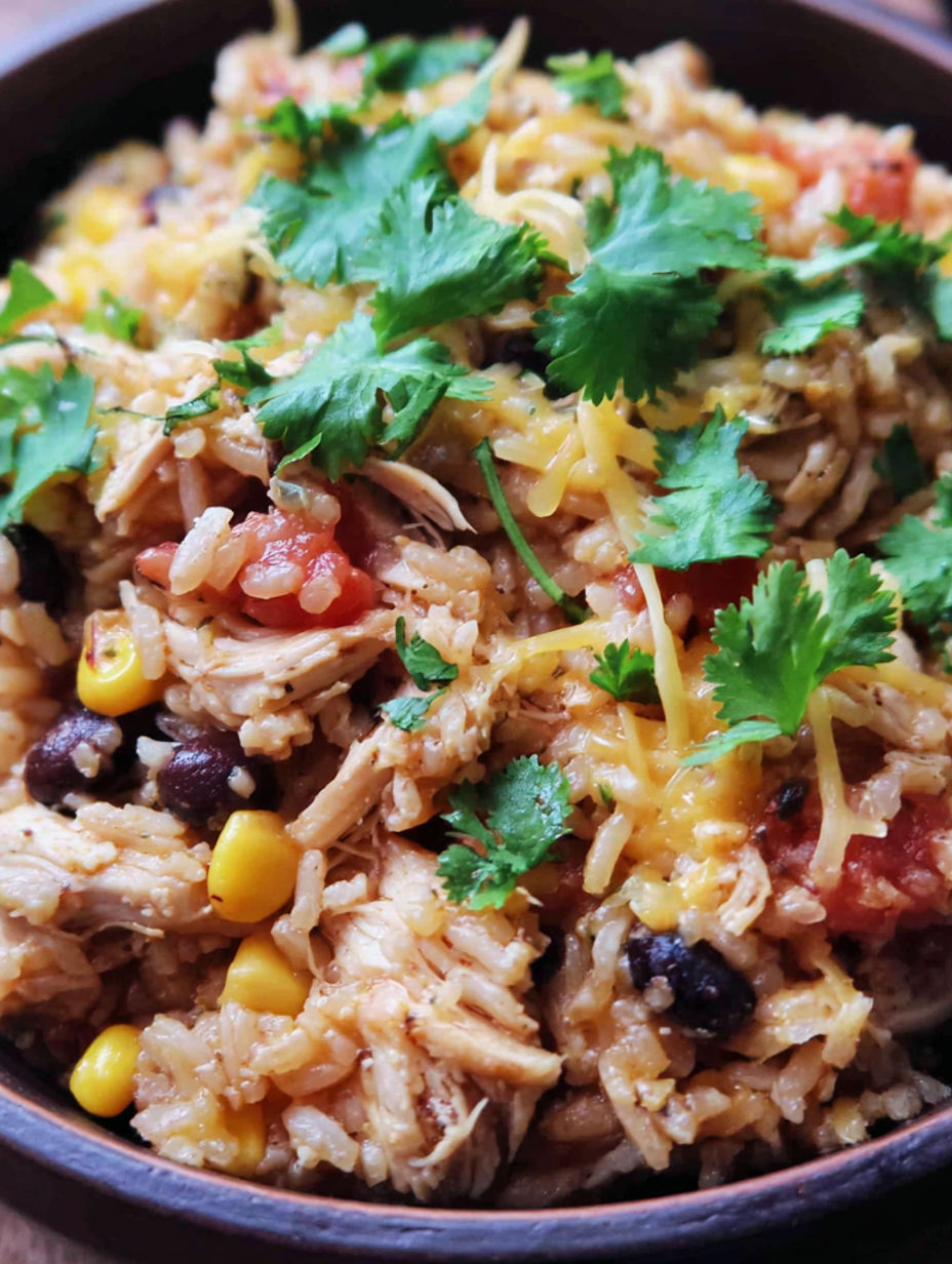 A bowl of rice with chicken, tomatoes, and cilantro.