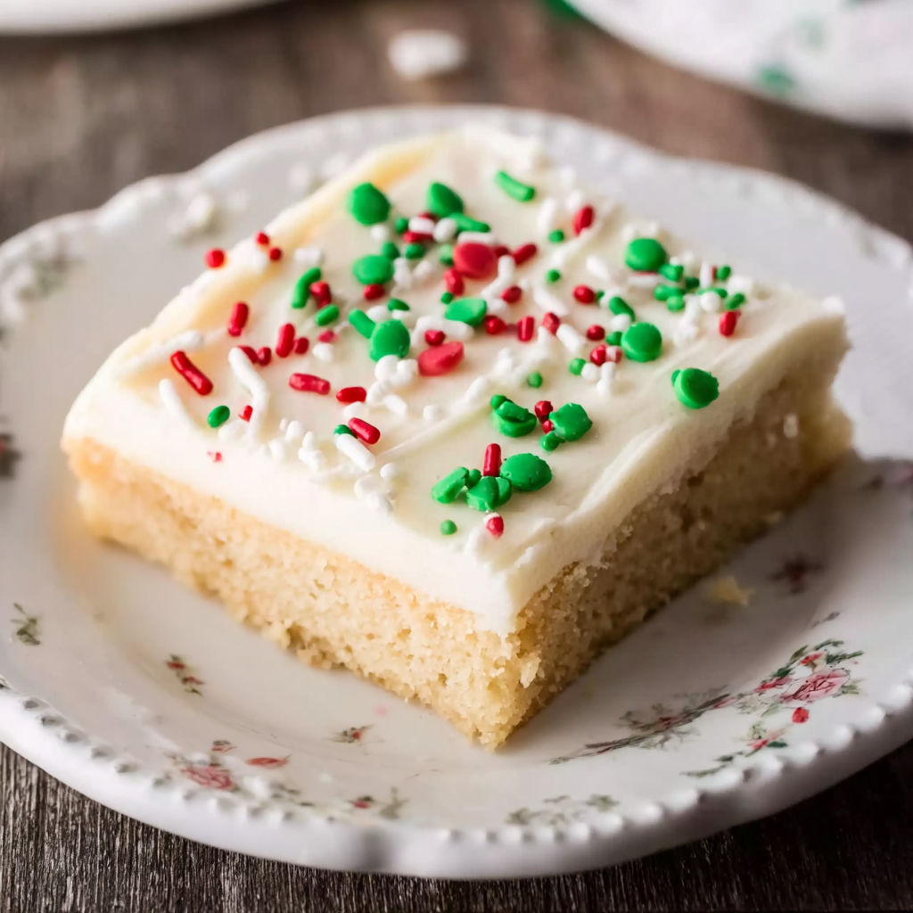 A white plate with a piece of cake on it.