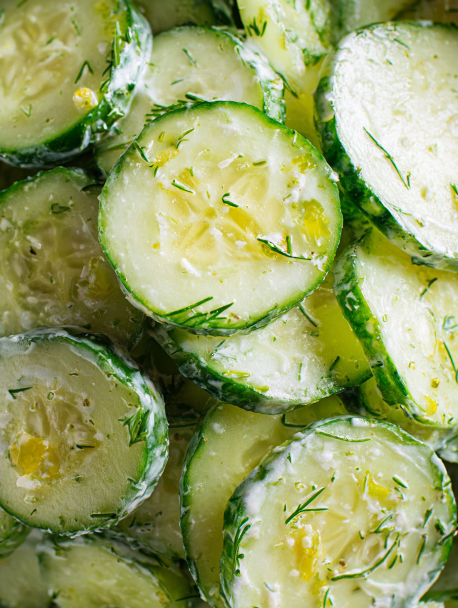 A pile of pickles with a white sauce on top.