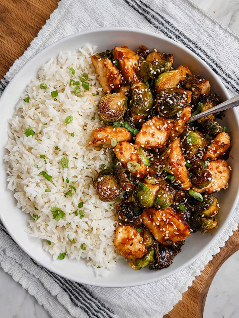 A bowl of rice and chicken with a spoon in it.