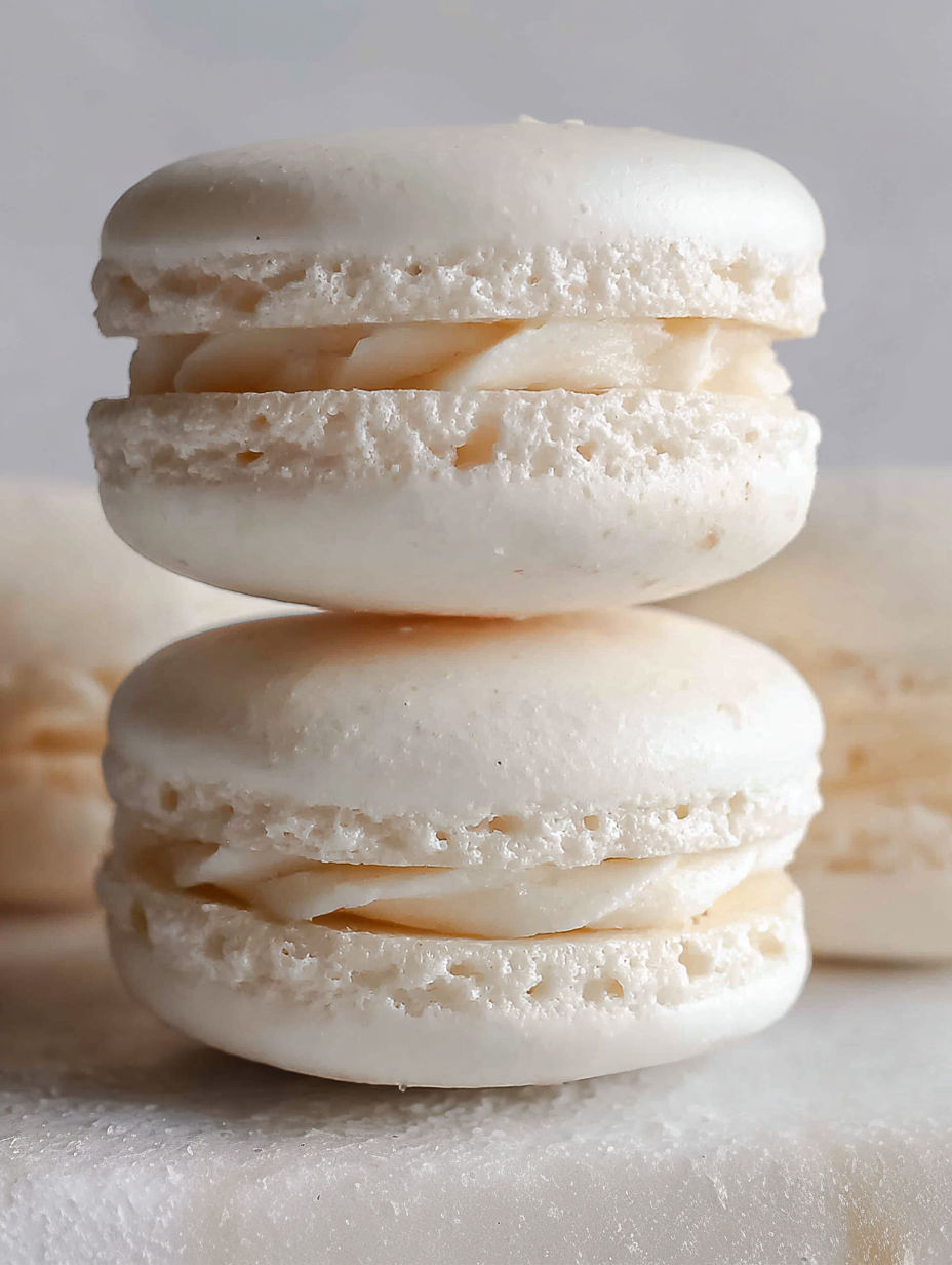A stack of macarons with a white cream filling.