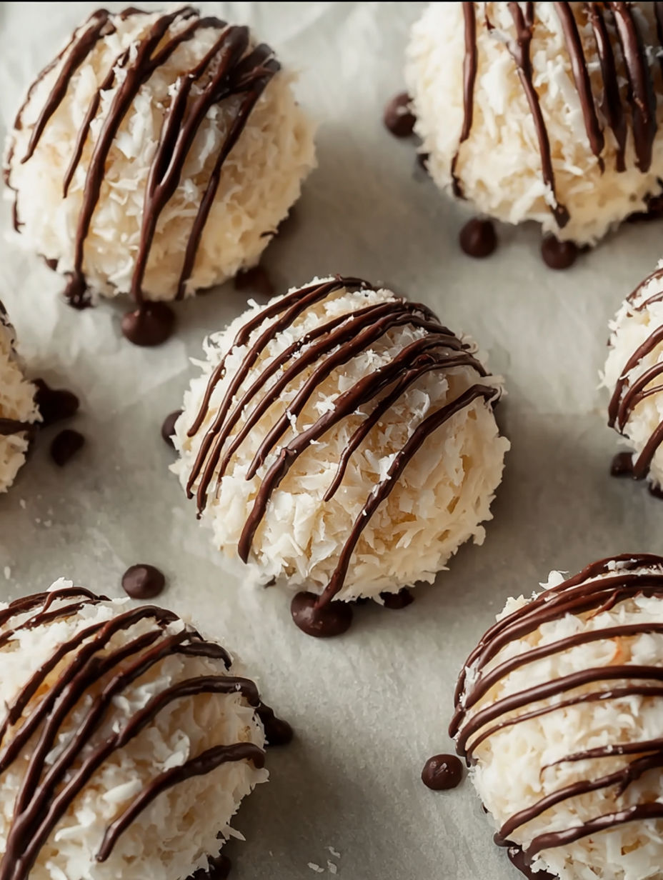 A close up of a no-bake kokos-keksbällchen with chocolate drizzle.