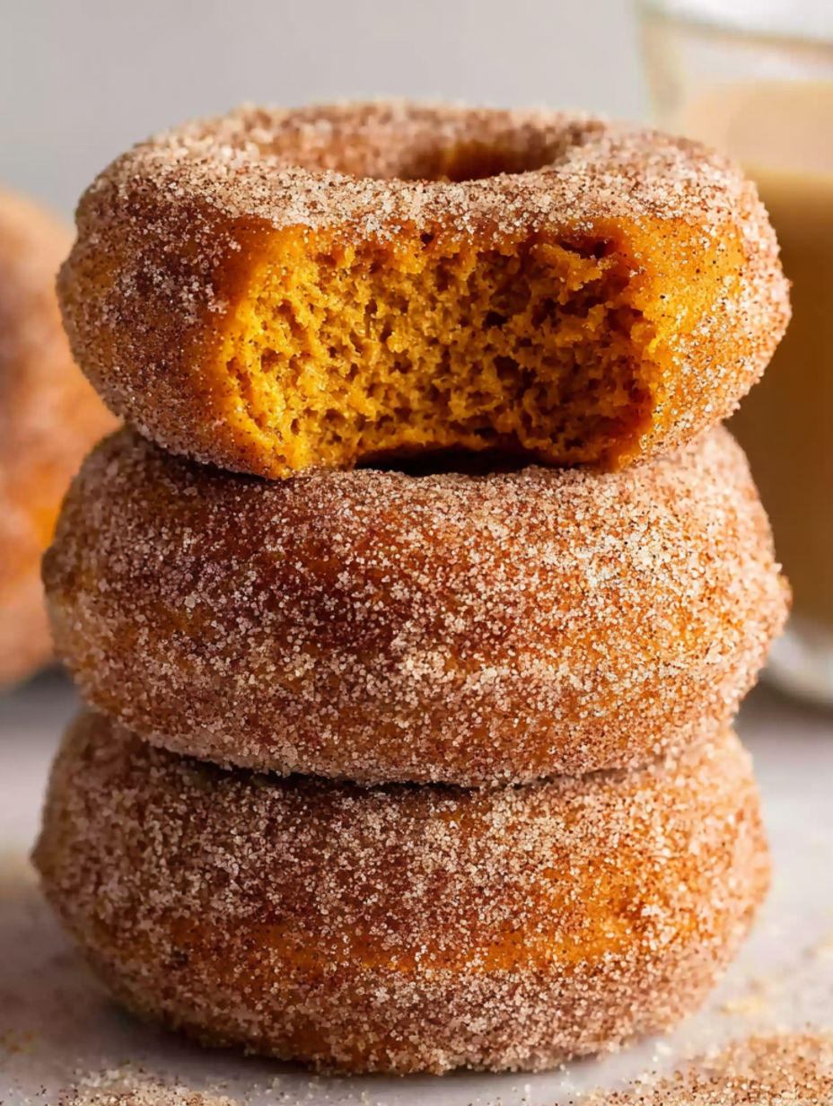 Pumpkin spice donuts stacked on top of each other.