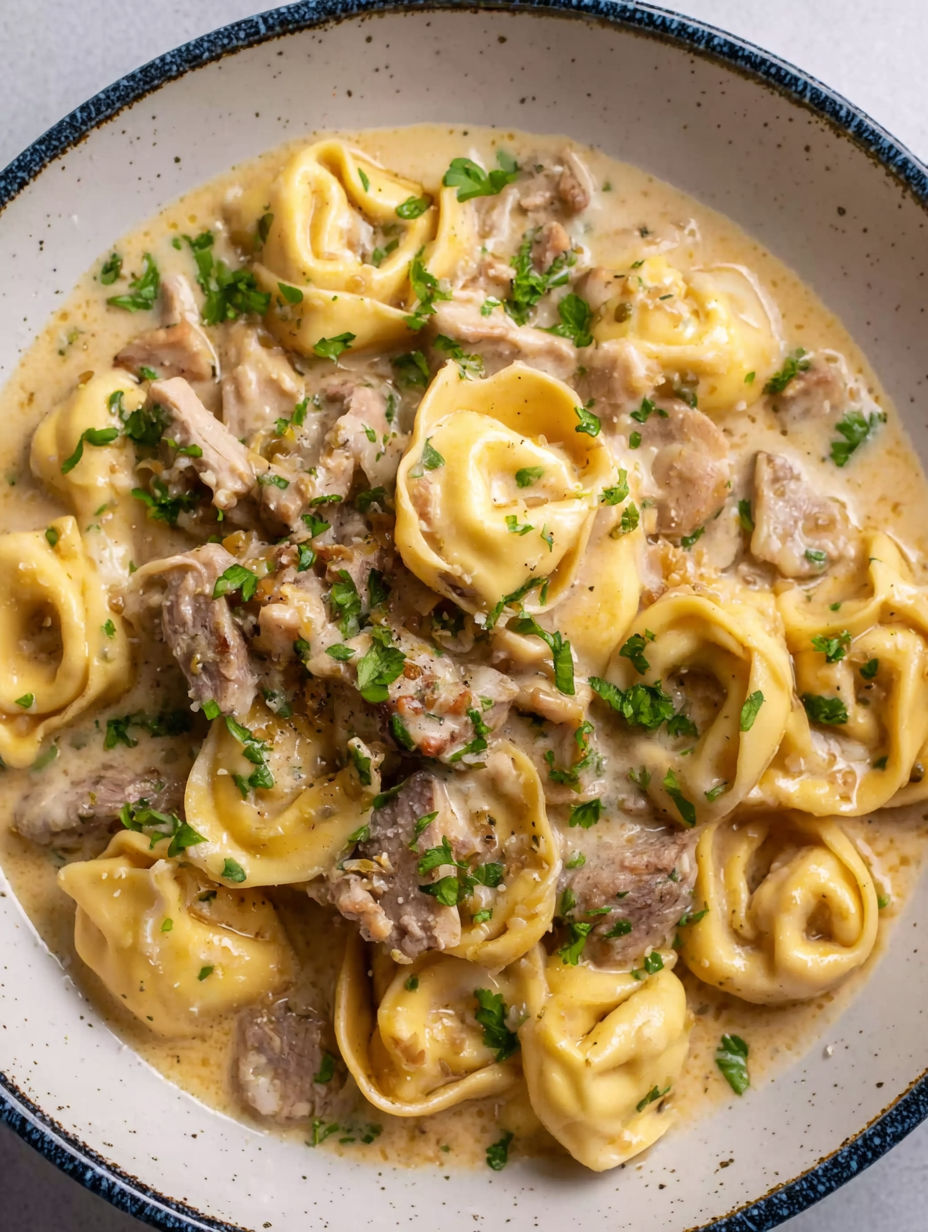 A bowl of pasta with meat and cheese.