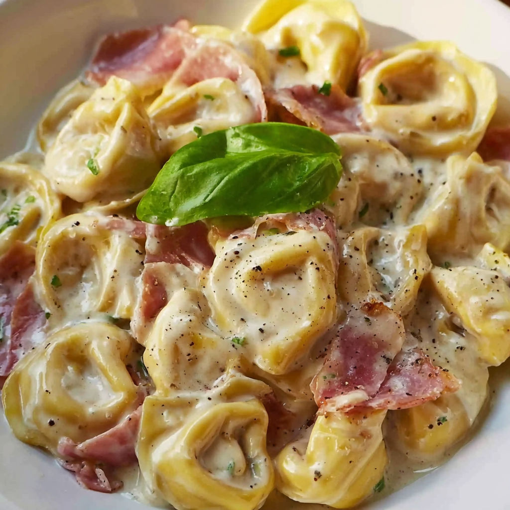 A plate of pasta with meat and greens.