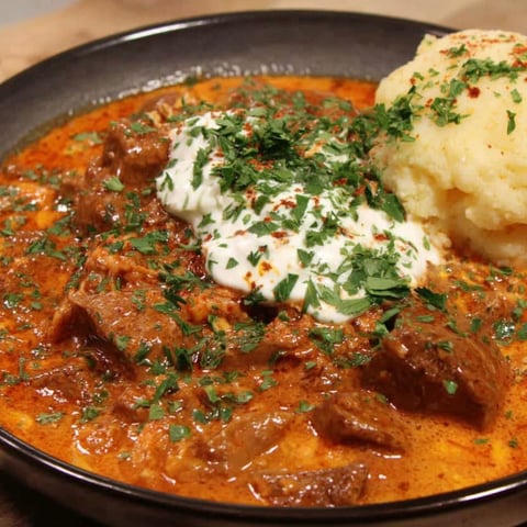 A plate of food with a meat dish and a potato.
