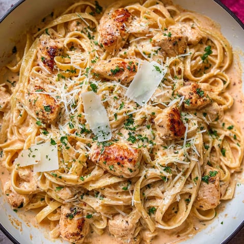 A bowl of pasta with chicken and cheese.