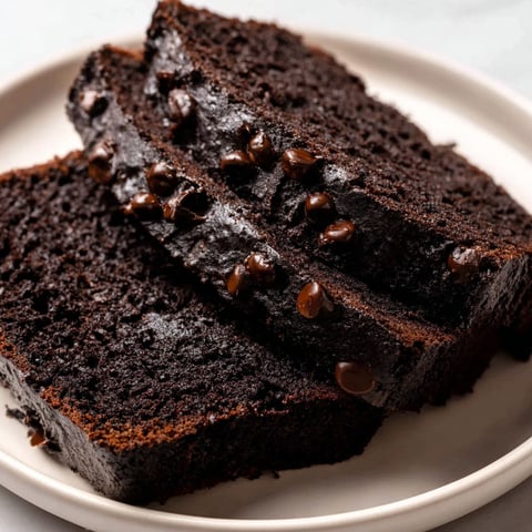 Two pieces of chocolate cake with chocolate chips.