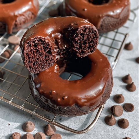 Two chocolate donuts with chocolate frosting and chocolate sprinkles.