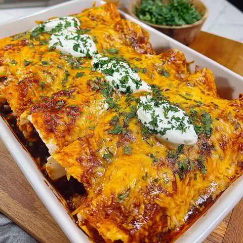 A white bowl filled with a delicious meal of bean and cheese enchiladas.
