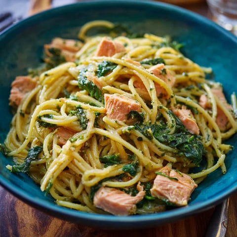 A bowl of pasta with meat and spinach.