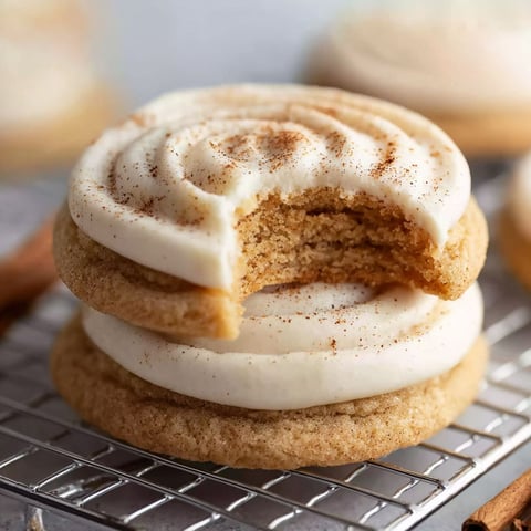 A cookie with white frosting and cinnamon.