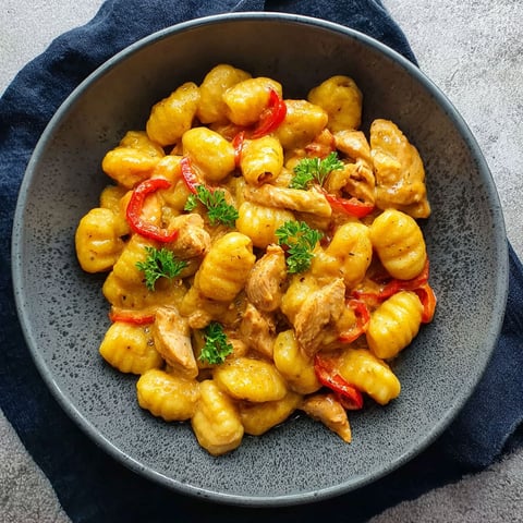 A bowl of pasta with meat and vegetables.