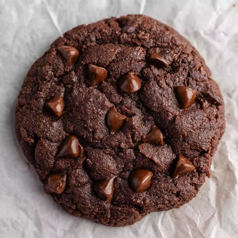 A chocolate chip cookie with chocolate drizzle.