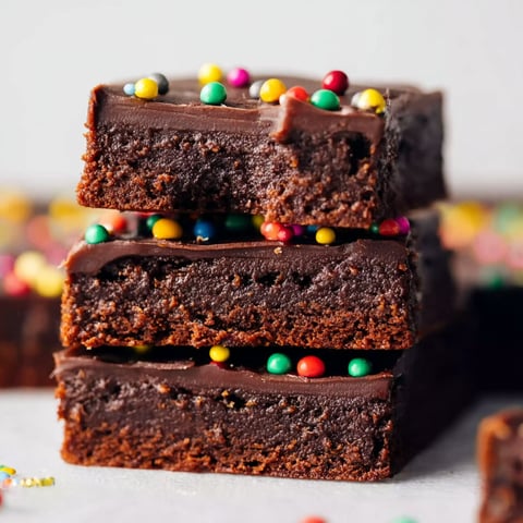 Three layers of chocolate brownies with sprinkles.