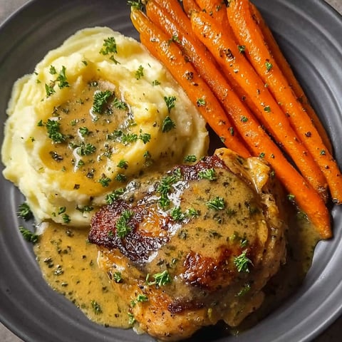 A plate of food with chicken, potatoes and carrots.