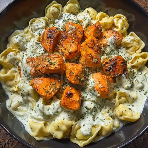 A bowl of pasta with chicken and cheese.