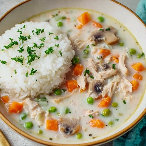 A bowl of soup with rice and chicken.