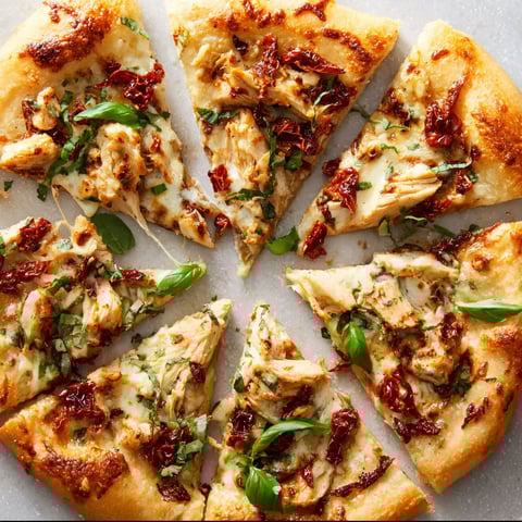A slice of chicken pizza with a green topping.