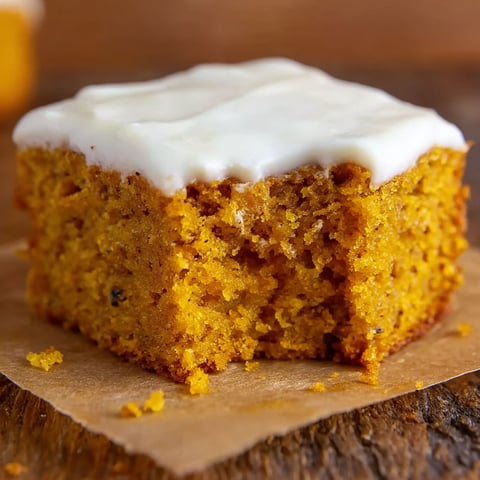 A slice of pumpkin bars with cream cheese frosting.