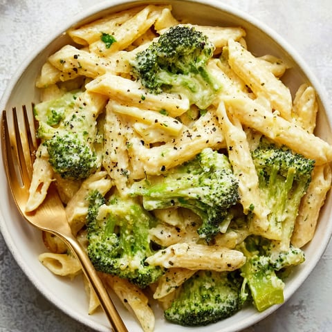 A bowl of pasta with broccoli.
